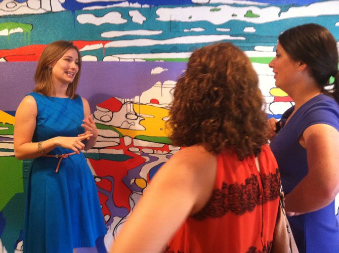 Resident artist Rachel Kerwin discusses her mural, Coloring Outside the Lines, with visitors on Thursday. 