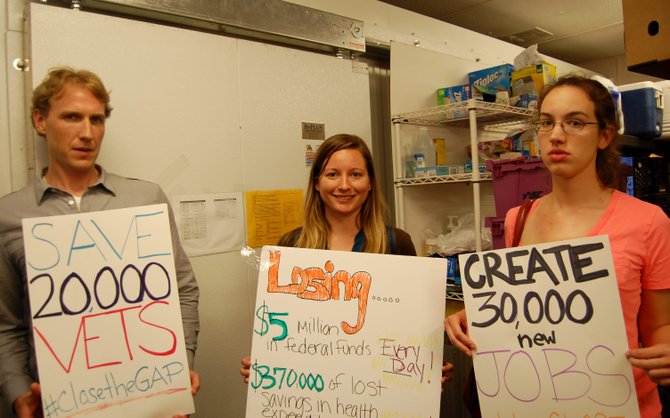 Aaron Smith, Erin Hemlin and Katherine Schally joined dozens of other community members advocating for Medicaid expansion on June 11 in Lorton.
