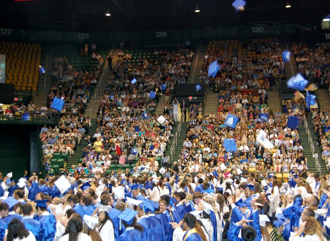 After receiving their diplomas and turning their tassels, new graduates of Robinson Secondary School throw their graduation caps in the air at the Patriot Center in Fairfax on June 17.