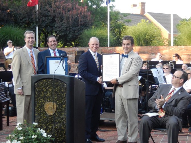 Resolution presentation: (From left) are Del. David Bulova, Dan Drummond, Steve Stombres and Sen. Chap Petersen, while City Electoral Board Chairman Rick Herrington and the City band applaud.