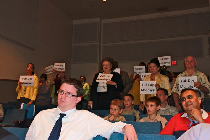 Audience members at the School Board meeting show their support for full-day Mondays.