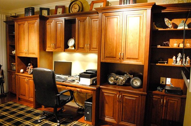 Bart Goldstein of Bart Goldstein Interior Design combined a mixture of hidden and open cabinetry with comfortable seating to create this home office.
 
