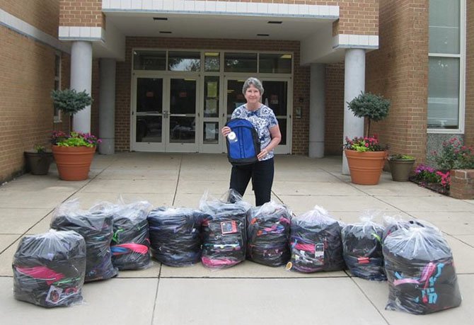 Pam Fruit, the backpack coordinator for Centreville Baptist Church, poses with some of the more than 150 backpacks her church provided last year via WFCM for students in need at London Towne Elementary. The photo was taken on delivery day.