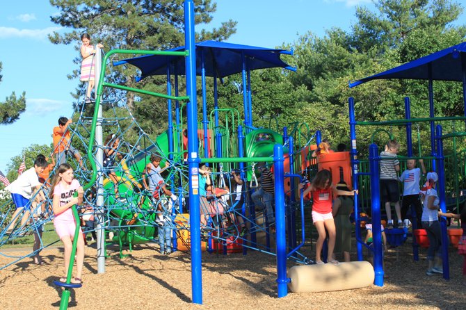 Children enjoy the playground for its dedication on July 4.