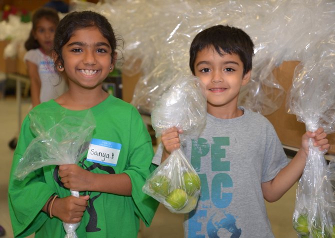 Happy to help, from left, Sanya Baig and Humza Sait. “And I can count to 5, then 6,” announced young Mr. Sait, proudly showing off some of the bags of limes the five-year-old had filled for the July 3 edition of the Project Food Boost food distribution in Herndon.