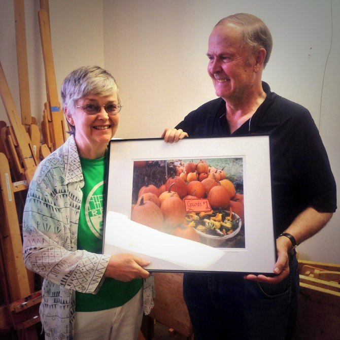 Anne Emerson and her husband display her photo “Herndon Rotary Club Pumpkin Stall II”. The 2014 photo exhibit displays the works of twenty-five local photographers, who took photos within the corporate limits of the Town of Herndon.