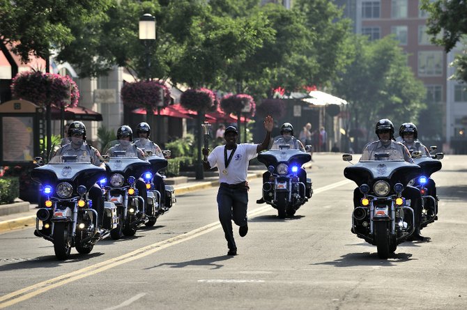 Fairfax County Fire and Rescue battalion chief Jerome I. Williams, a resident of Centerville, carried a lighted torch for the kickoff of the summer Fairfax 2015 WPFG games at Reston Town Center.