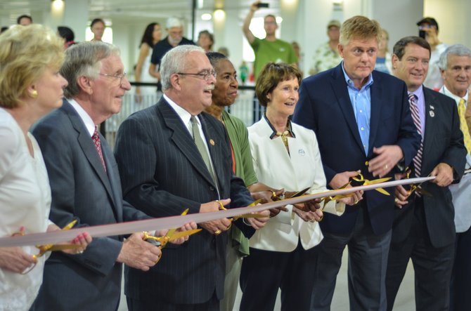 Virginia state senator Janet Howell, Del. Ken Plum, US Congressman Gerald Connolly, Supervisor Cathy Hudgins, Chairman for the Fairfax County Board of Supervisors Sharon Bulova, Supervisor John Cook, Supervisor Pat Herrity, and Del. Tom Rust prepare for the ceremonial ribbon cutting at the Wiehle-Reston East garage held on July 19 in Reston.
