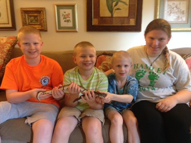 From left -- John, Robbie, Andrew, and Ashley King hold their pet Python Zed.