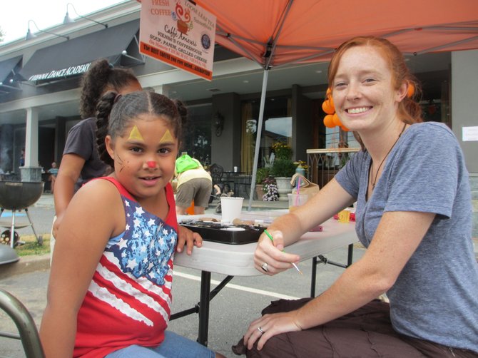 Six-year-old Nina Mendez has her face painted by Caffe Amouri volunteer Kristen Amouri. Nina’s mom said the family came to support the Lamb Center.