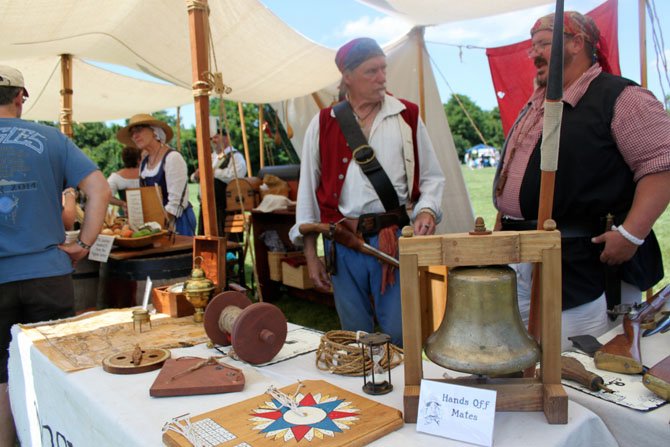 Pirate re-enactors Alpheus Chewning and Jack Morgan show off reproductions of 17th and 18th century compasses and lamps at Pirate Fest.