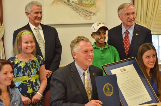 Governor Terry McAuliffe displays the proclamation making the third week of January Teen Cancer Awareness week in Virginia along with young cancer survivors and state delegates Tom Rust and Ken Plum.