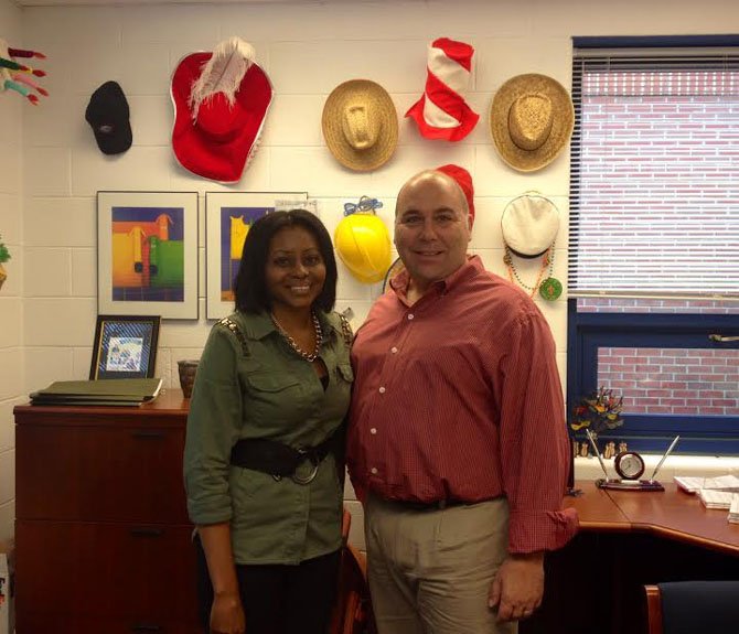 Principal Don Hutzel and Assistant Principal Sharon Jones of Churchill Road ES in front of a display of hats that reflect the school’s spirit days.