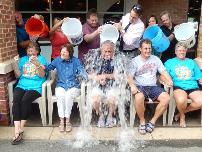 Fairfax City Mayor Scott Silverthorne gets drenched. (From left) are Jo Ormesher, Sharon Bulova, Scott Silverthorne, Chap Petersen and Beverly Myers. Petersen’s daughter, Eva, a Fairfax High sophomore, had the honor of dousing her dad with ice water.
