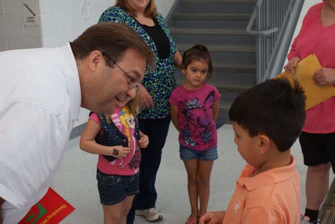 Providence Elementary School [PES] Assistant Principal Dan Phillips welcomes a rising kindergartner.
