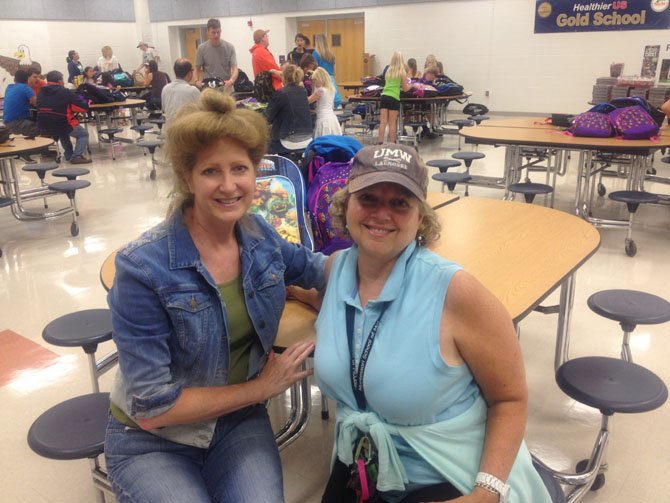 Karen Hilliard and Leslie Montague both volunteered for the backpack drive held at Herndon Hutchison Elementary on Aug. 23.
