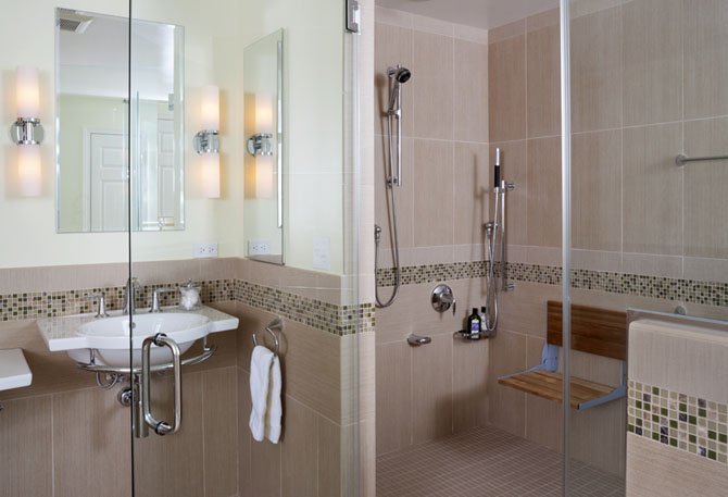 When remodeling this bathroom, Glickman Design Build added a bench to this shower. Such features can help seniors to downsize and live alone safely.
