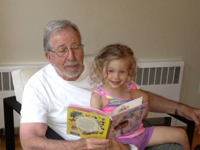 Elliot Wilner reads to his granddaughter, Yael Fritschie, who is not yet a member of either the New Yorker or bicycle group.
