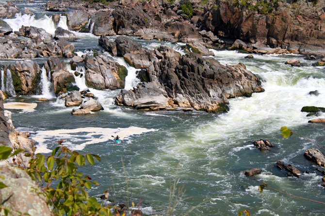 A kayaker paddles below the falls near an overlook at Great Falls Park.