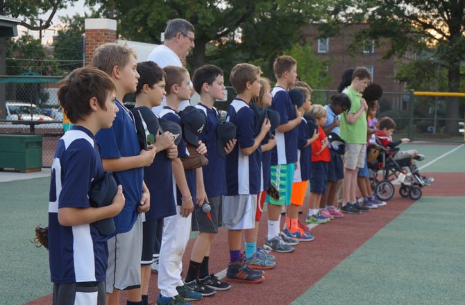 Players and volunteers  listen to the National Anthem Sept. 19 prior to the opening game of the 2014 Miracle League fall season at the Nannie J. Lee Center.