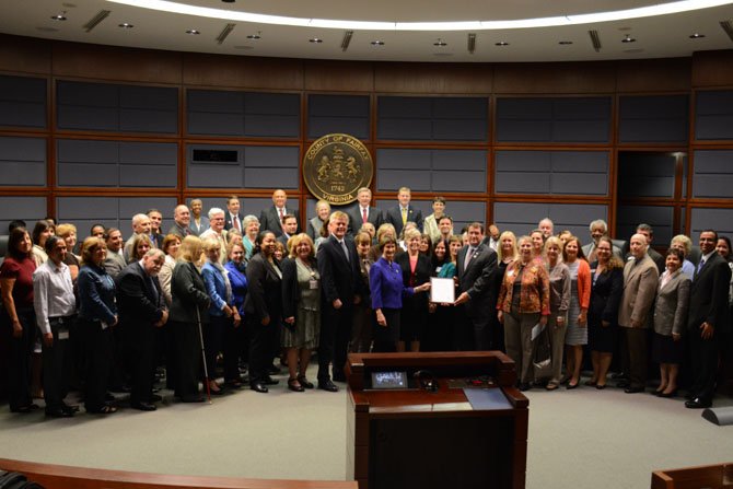 Individuals who helped develop the 50+ Community Action Plan pose with the Fairfax County Board of Supervisors.
