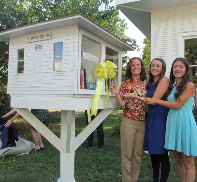 Vienna’s late Mayor M. Jane Seeman’s daughter, Linda Colbert, now a Town Council member, and granddaughters, Hannah and Heather Colbert, cut the yellow ribbon tied around the mini-library perched birdhouse-height. Colbert reflected on her mother’s love of reading in her remarks.
