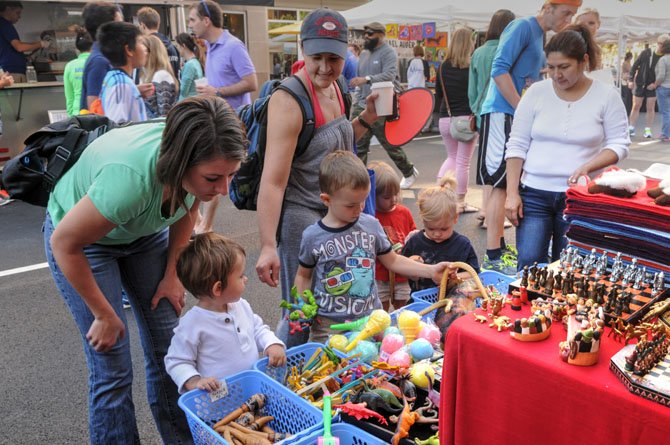 Children browse through the trays of handmade toys and instruments at Celest Hernandez’s booth.