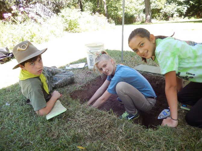 (From left) Students James McVicker, Corina Gribble and Haly Yungwirth search for historic artifacts in the ground.