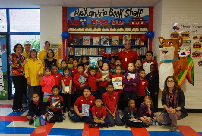 Students of Mount Vernon Community School pose for a group photo Oct. 6 with their principal Peter Balas, ACPS School Board chair  Karen Graf, DreamDog Foundation executive director Lorraine Friedman and other teachers and volunteers to officially open the newest Alexandria Book Shelf. The dedication also marked the one-year anniversary of the founding of the DreamDog Foundation, the organization that created and runs the Alexandria Book Shelf program.