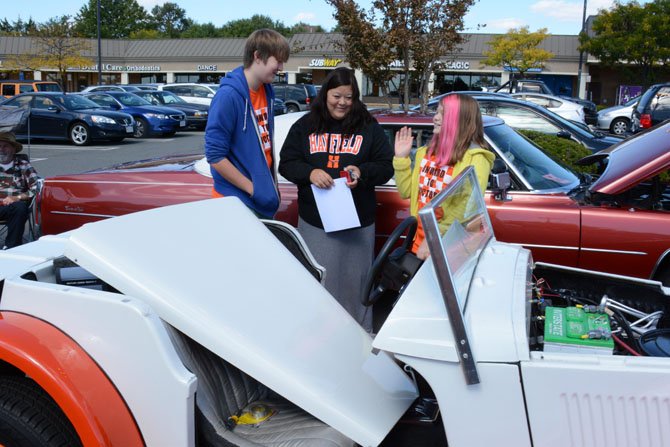 (From left) Principal Tremaine’s son Grant, a junior at South Lakes High School, wife Robyn of Reston and daughter Parker, in fifth grade at Hunters Woods Elementary school, check out the Hayfield Auto Tech department’s project car: a 1937 Jaguar SS100.