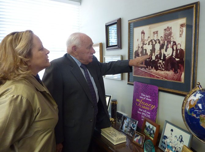 John McEnearney reminisces with daughter Maureen McEnearney Dunn over the first photo taken of the firm's agents in 1980.