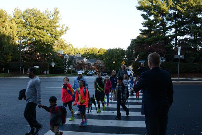 Braddock Supervisor John Cook greets students, parents and four-legged friends as they cross Burke Centre Parkway on National Walk to School Day.