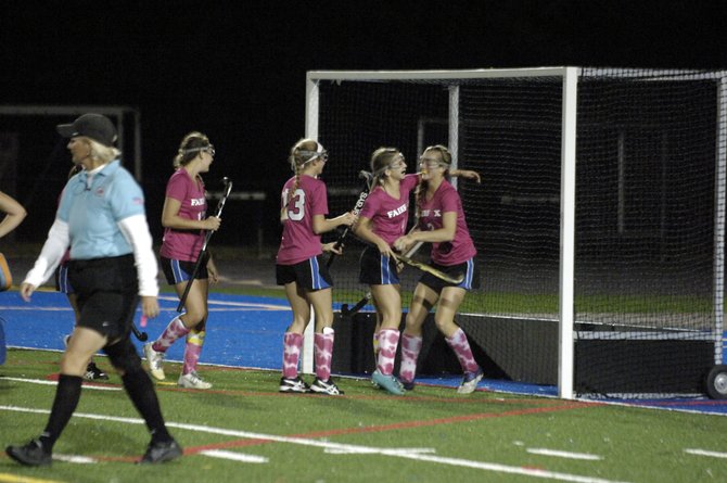 Members of the Fairfax field hockey team celebrate with sophomore Emily Deivert, right, after she scored one of her two goals against Madison on Oct. 9.