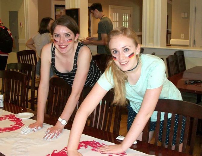 Kate Meyer (left) and friend Hannah work together on a banner for Austria in their arts-and-crafts class at the academy.
