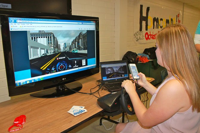 Langley High School senior Hanna Hunt behind the wheel of a texting and driving simulator on Oct. 16. Students could sign a pledge to never text again as a part of the school year’s theme of road safety.
