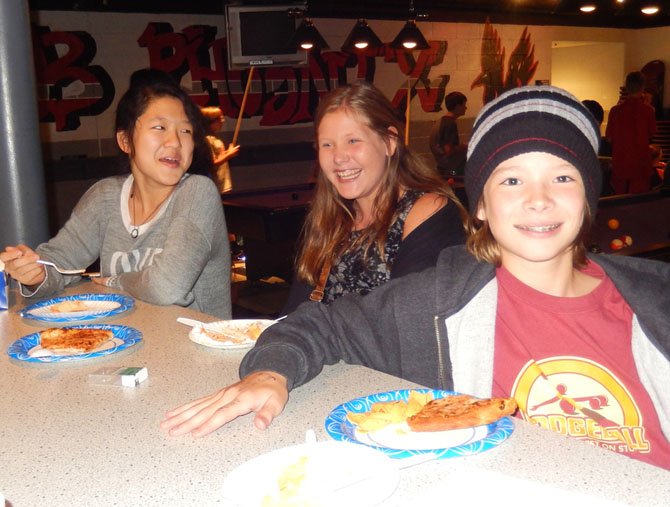 Enjoying pizza and some laughs are (from left) Thoreau Middle students Kelly Hsu, Kyra Sanders and Graham McCarthy.
