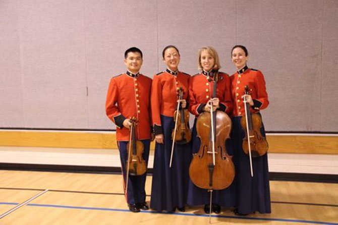 Members of “The President’s Own” United States Marine String Quartet posed in their dress uniforms, a design which originated in the 1700s, after their performance at Churchill Road Elementary. From left are SSgt Sheng-Tsung Wang and SSgt Chaerim Smith (violin), SSgt Charlaine Prescott (cello) and Ssgt Sarah Hart (viola).