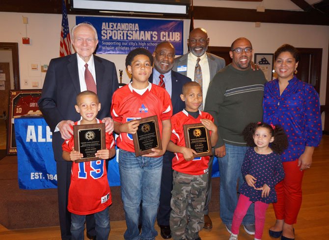 Greer brothers Julian, 7, Charles, 13, and Miles, 9, front, are joined by their parents Jeremie and Elena, at right, and sister Leila, 3, after being presented the Alexandria Sportsman’s Club  Athlete of the Month Awards Oct. 21 at the Old Dominion Boat Club. With them in back are ASC president Allan Kaupinen, Mayor Bill Euille and Redskins great Mike Nelms.