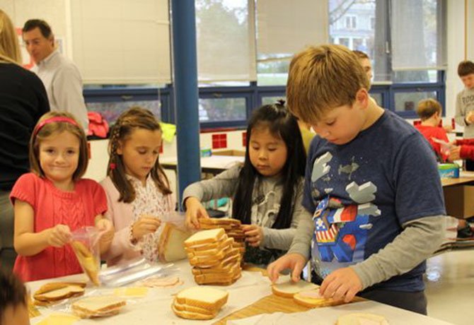 Churchill Road second graders Avery Orfitelli, Zelie Vernon, Felecia Lee and George Gaulding get first-hand knowledge of a production line, while making sandwiches for Martha's Table in Washington, D.C.