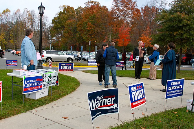Voters talk near the volunteer booths as they exit the polls at Great Falls Library on Tuesday.