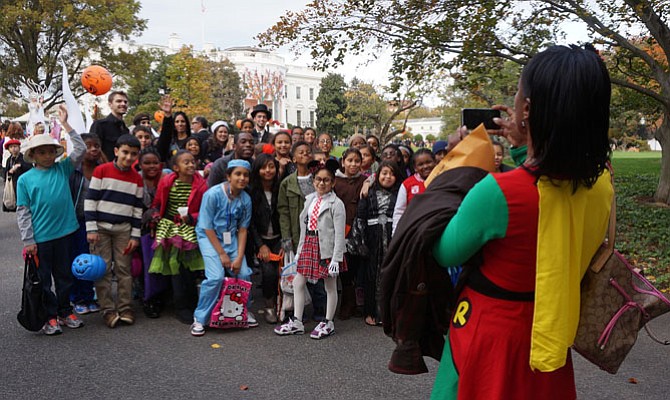 Patrick Henry Elementary School principal Ingrid Bynum, right,  takes a group photo of students and teachers on the South Lawn of the White House following a special Halloween visit Oct. 31.