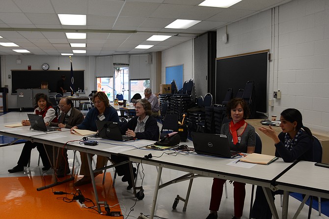 Election officials at West Springfield High School wait to process voters. (From left) Chea Belfort of Burke, Pradeep Chaturvedi of Springfield, Jeanette Hantke of West Springfield, Vivina McVay of Burke, Chris Bolognese of Springfield and Nour Nourey of Alexandria.
