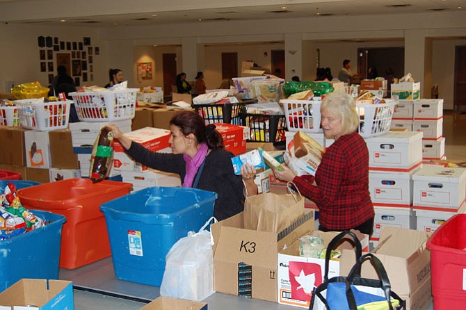 Volunteers help to sort food at food drive. Five-hundred twenty-five households in southeastern Fairfax County were served a Thanksgiving food basket from Lorton Community Action Center, thanks to donations from the community and volunteers to organize the packing.
