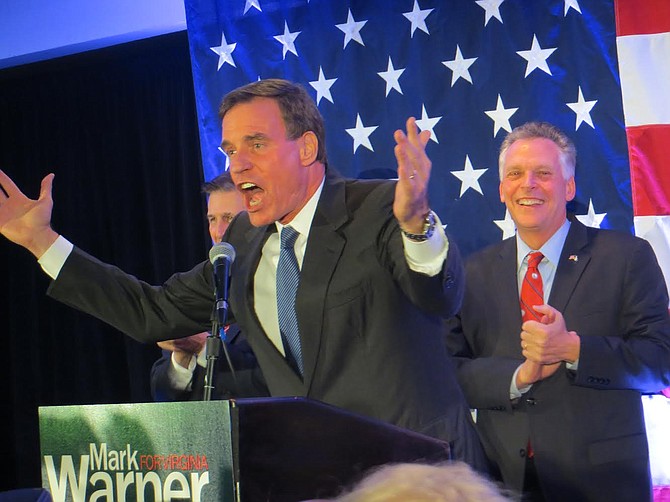 U.S. Sen. Mark Warner, with Don Beyer and Gov. Terry McAuliffe behind him, addresses the crowd on election night.