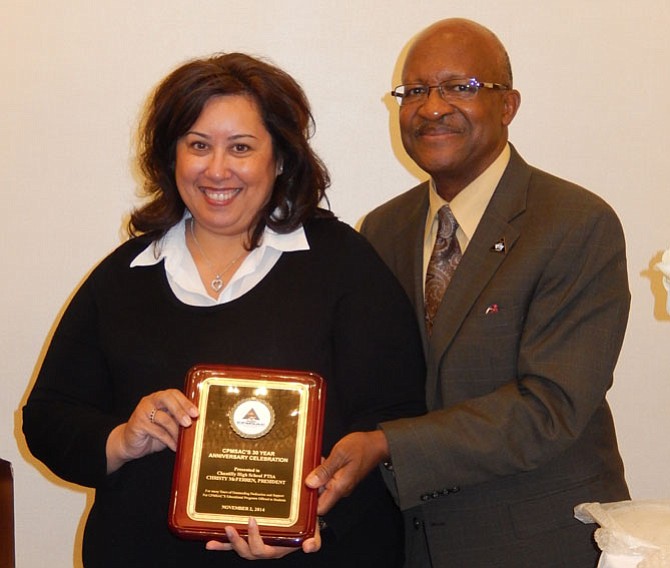 Christy McFerren is happy to get a plaque from Johnny Nelson.
