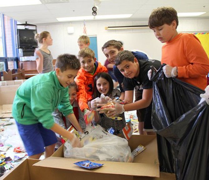 Churchill Road sixth graders Sebastian Silvestro, Alana Boiardi, Spencer Nash, Mallory Bernstein, Nate Fimbres, Kevin Kaldes and Conard Racich promote waste reduction by packaging juice pouches and chip bags for upcycling.