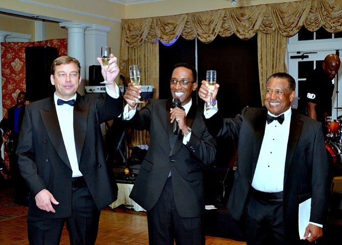  Hopkins House board chair Mark Eisenhour, president J. Glenn Hopkins and host committee chairman Robert Hicks raise their glasses in an anniversary toast.