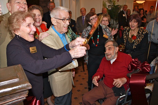 Residents Betty Ogg, Tom Rainey and Marc Nevenstone cheer after cutting the ribbon during Brightview Senior Living’s grand opening.
