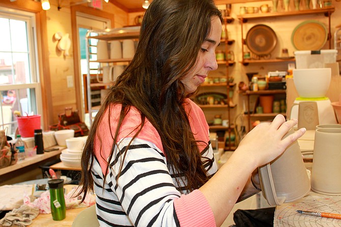 Hand builder Kacey Boyce works on creating tankards at Potter’s Fire’s studio.
