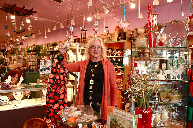 The Artisans co-owner, Shannon Denny Price, hangs up some of the new felt ornaments in the shop.
